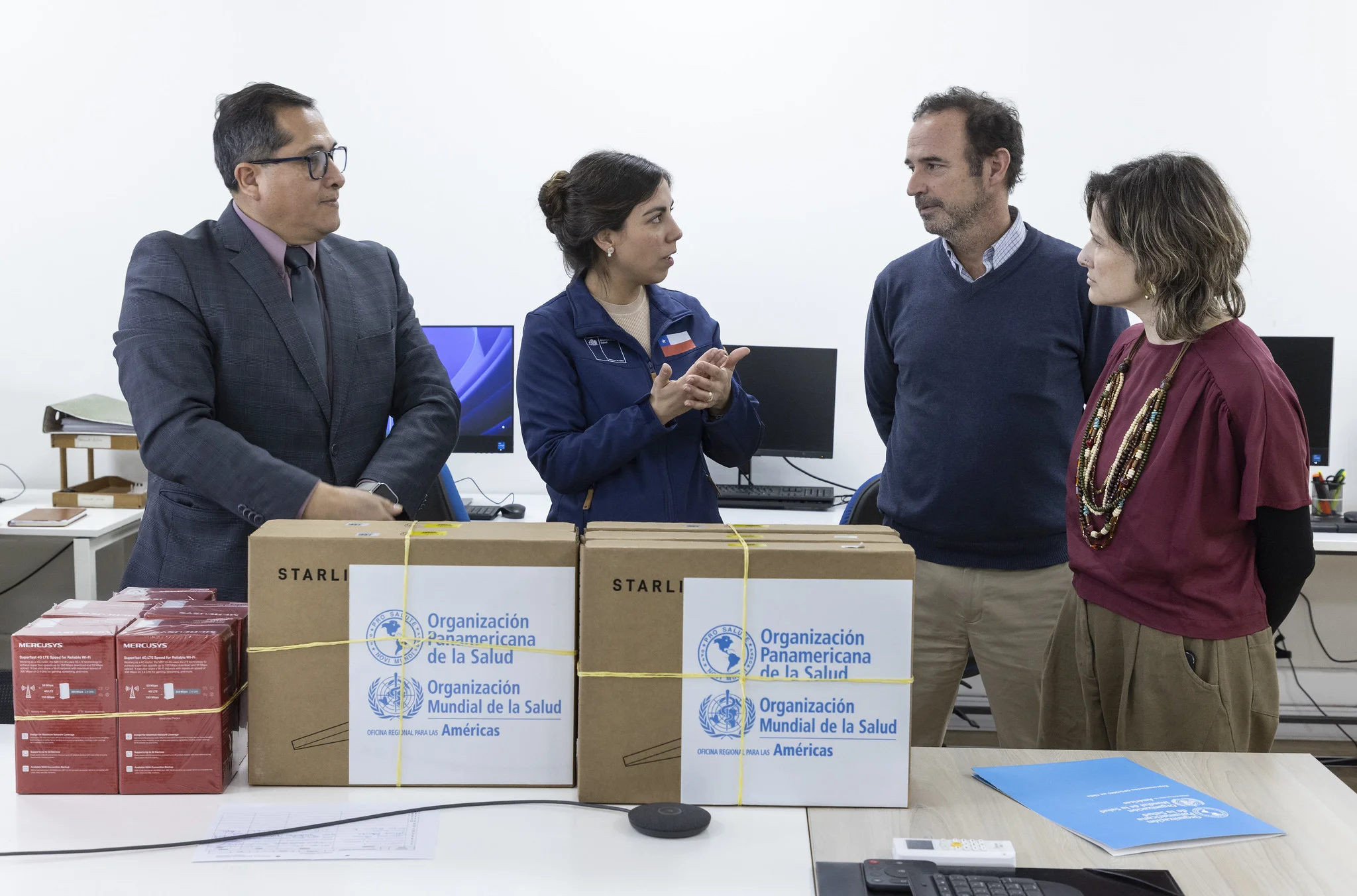 Representantes de salud junto a cajas de equipos satelitales donados por OPS/OMS al Ministerio de Salud de Chile